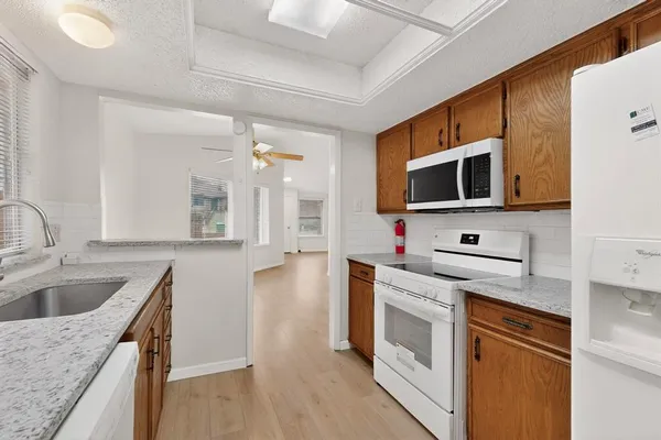 a kitchen with stainless steel appliances granite countertop a sink and a stove top oven
