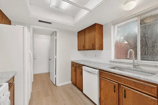 a kitchen with stainless steel appliances granite countertop a sink and a granite counter tops with wooden floors