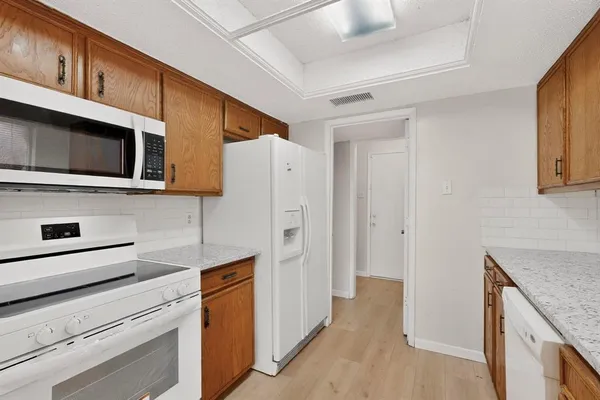 a kitchen with stainless steel appliances white cabinets and a refrigerator