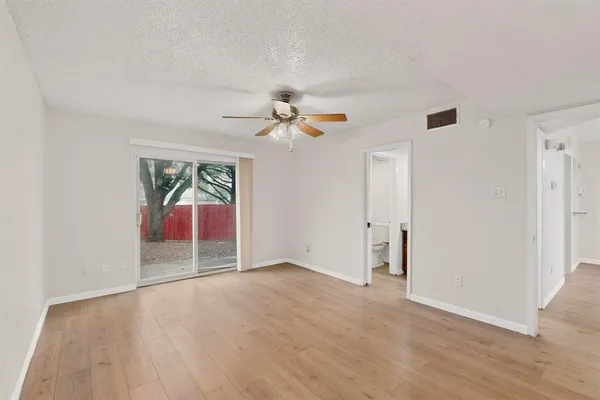 an empty room with fan and windows