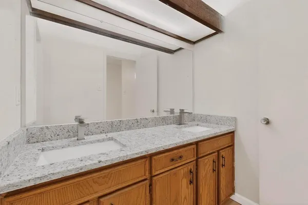 a bathroom with a granite countertop sink and double vanity