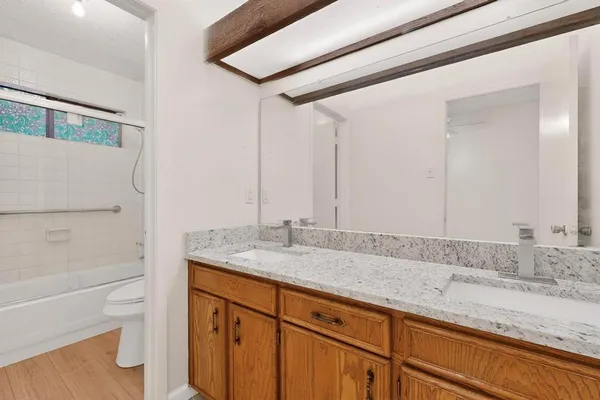 a bathroom with a granite countertop sink and a mirror
