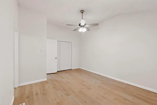an empty room with a fan & a ceiling fan