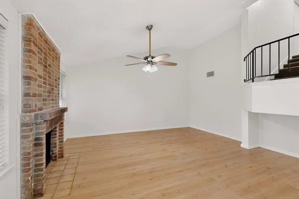 a view of a livingroom with wooden floor and a staircase