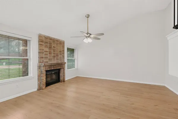 a view of an empty room with a fireplace and a window