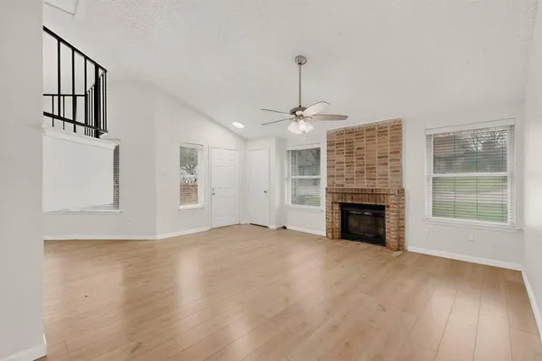 a view of an empty room with a window and fireplace