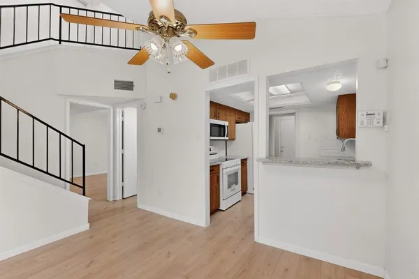 a view of a kitchen with a sink cabinets wooden floor and a large window
