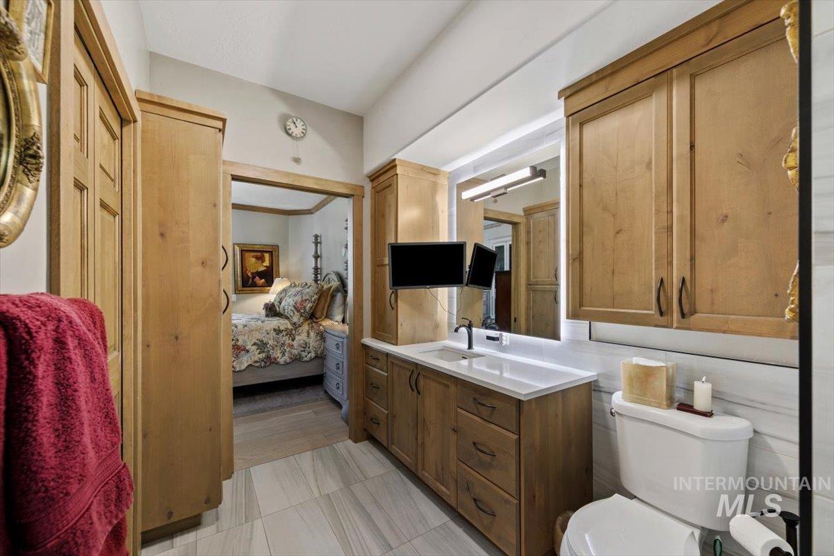 79 East Aikens Road, Unit 304 Eagle, ID 83616 - Photo 20 of 42 Elongated vanity with a single basin, white countertop, and wood-finish cabinetry