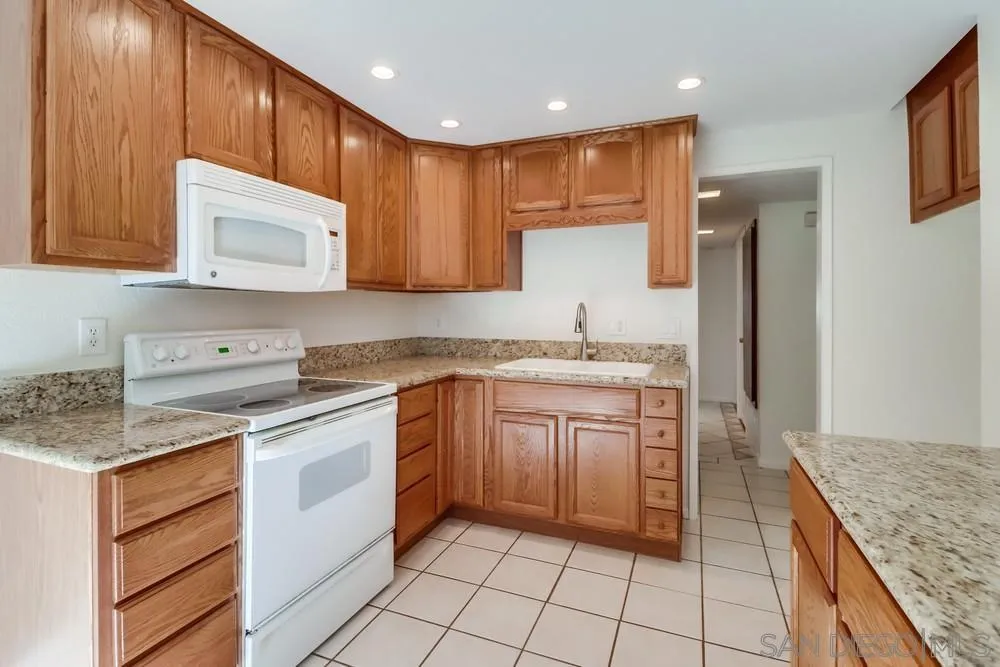 2157 Arnold Way, Unit 201 Alpine, CA 91901 - Photo 15 of 41 a kitchen with stainless steel appliances granite countertop wooden cabinets a sink and dishwasher