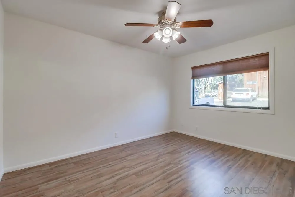 2157 Arnold Way, Unit 201 Alpine, CA 91901 - Photo 20 of 41 a view of an empty room with wooden floor and a window
