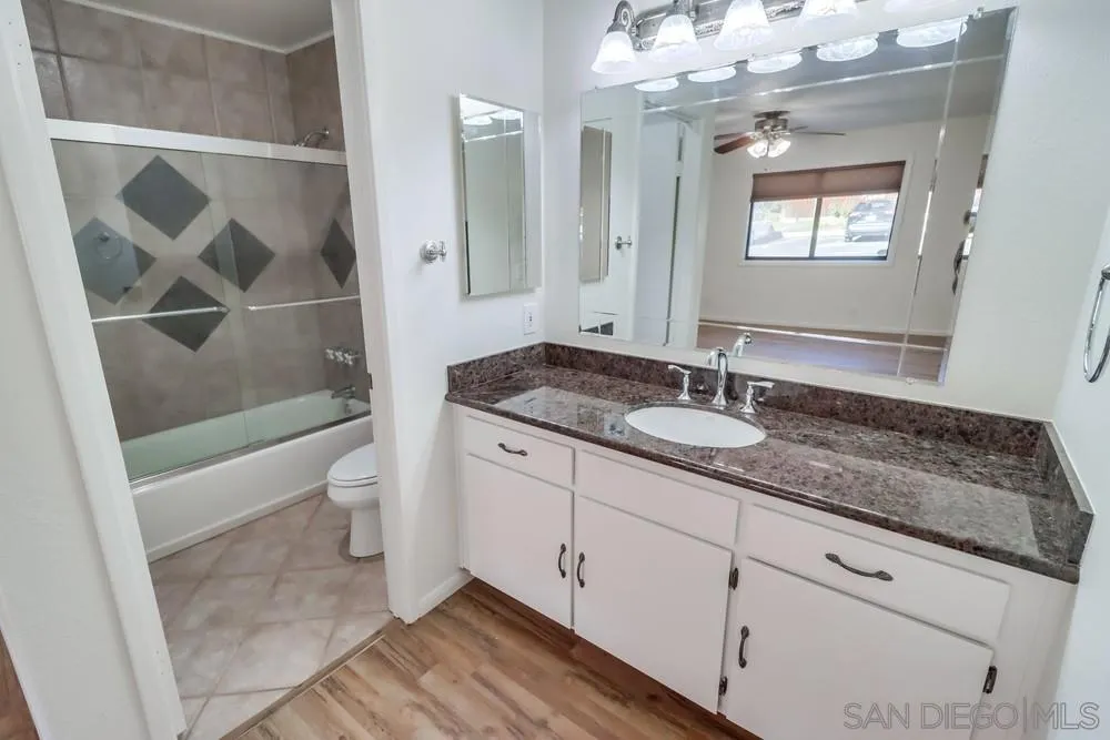 2157 Arnold Way, Unit 201 Alpine, CA 91901 - Photo 28 of 41 a bathroom with a granite countertop sink a toilet a mirror and shower