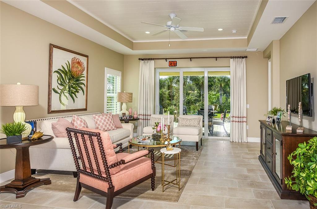 4048 Pegasus Way Naples, FL 34120 - Photo 3 of 13 a living room with furniture a large window and a flat screen tv