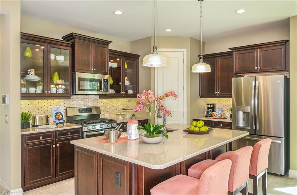 4048 Pegasus Way Naples, FL 34120 - Photo 6 of 13 a kitchen with stainless steel appliances a sink a stove a refrigerator and cabinets