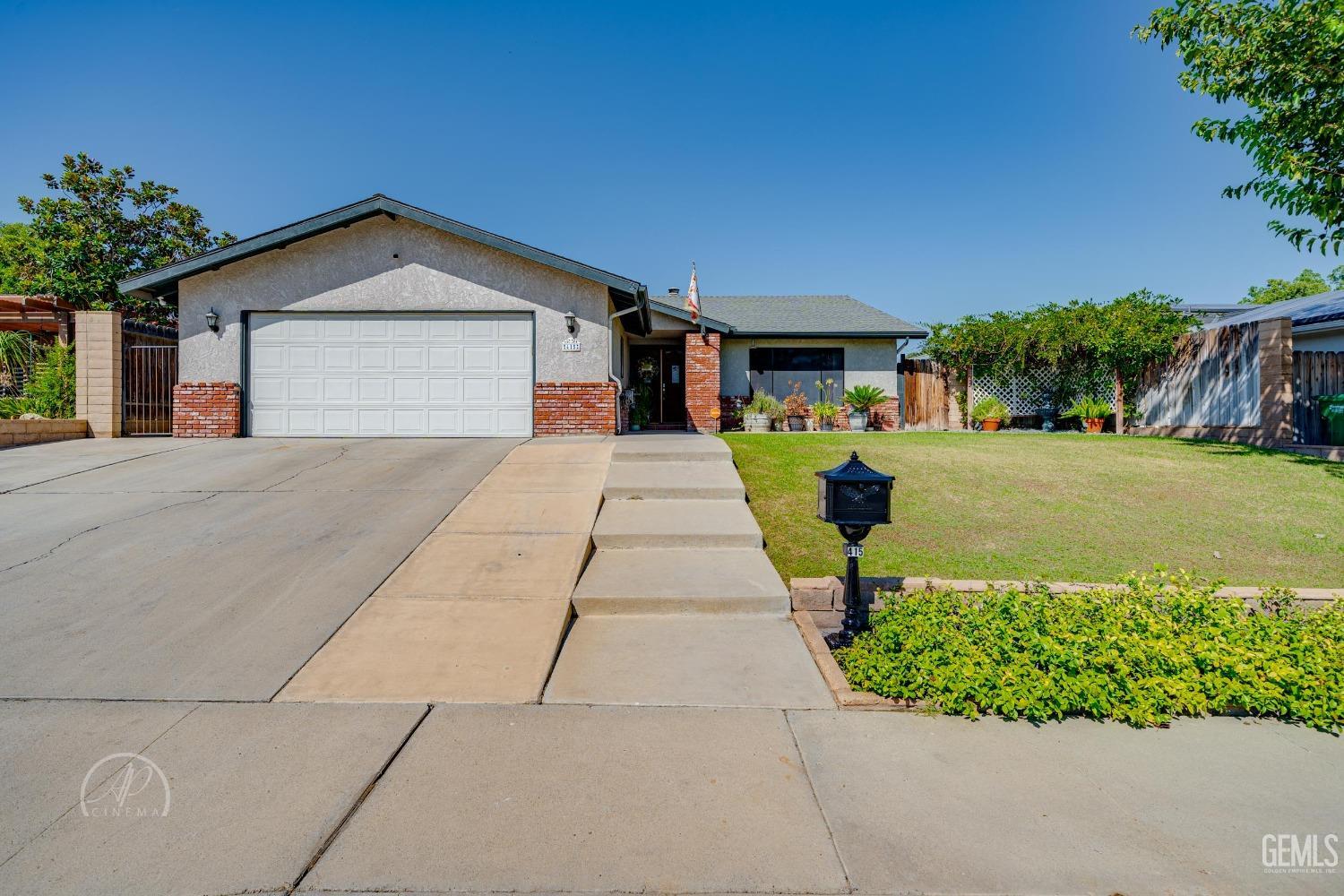 a front view of a house with a yard and potted plants
