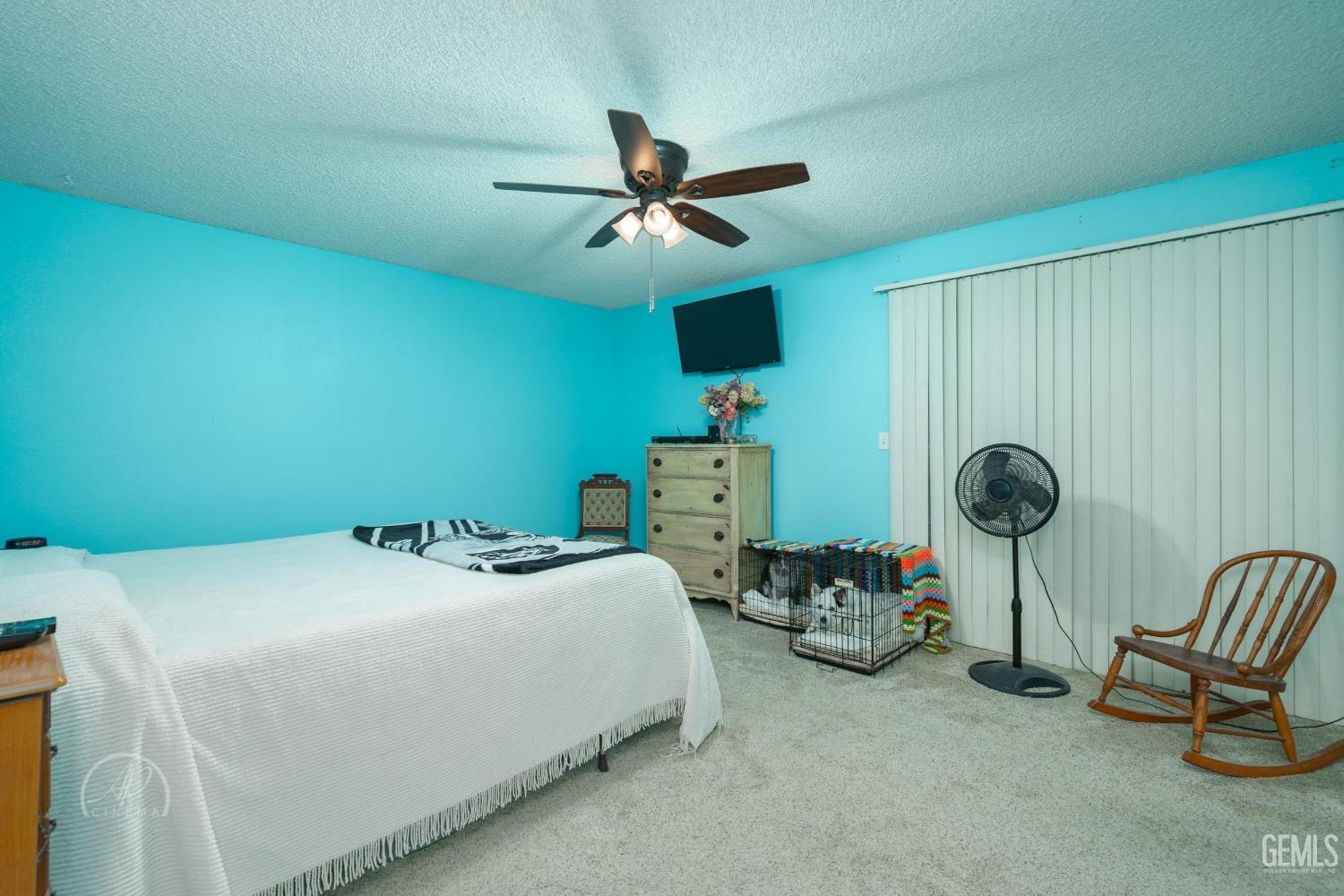 Undisclosed Address Taft, CA 93268 - Photo 17 of 32 a bedroom with a bed a chandelier and a chair