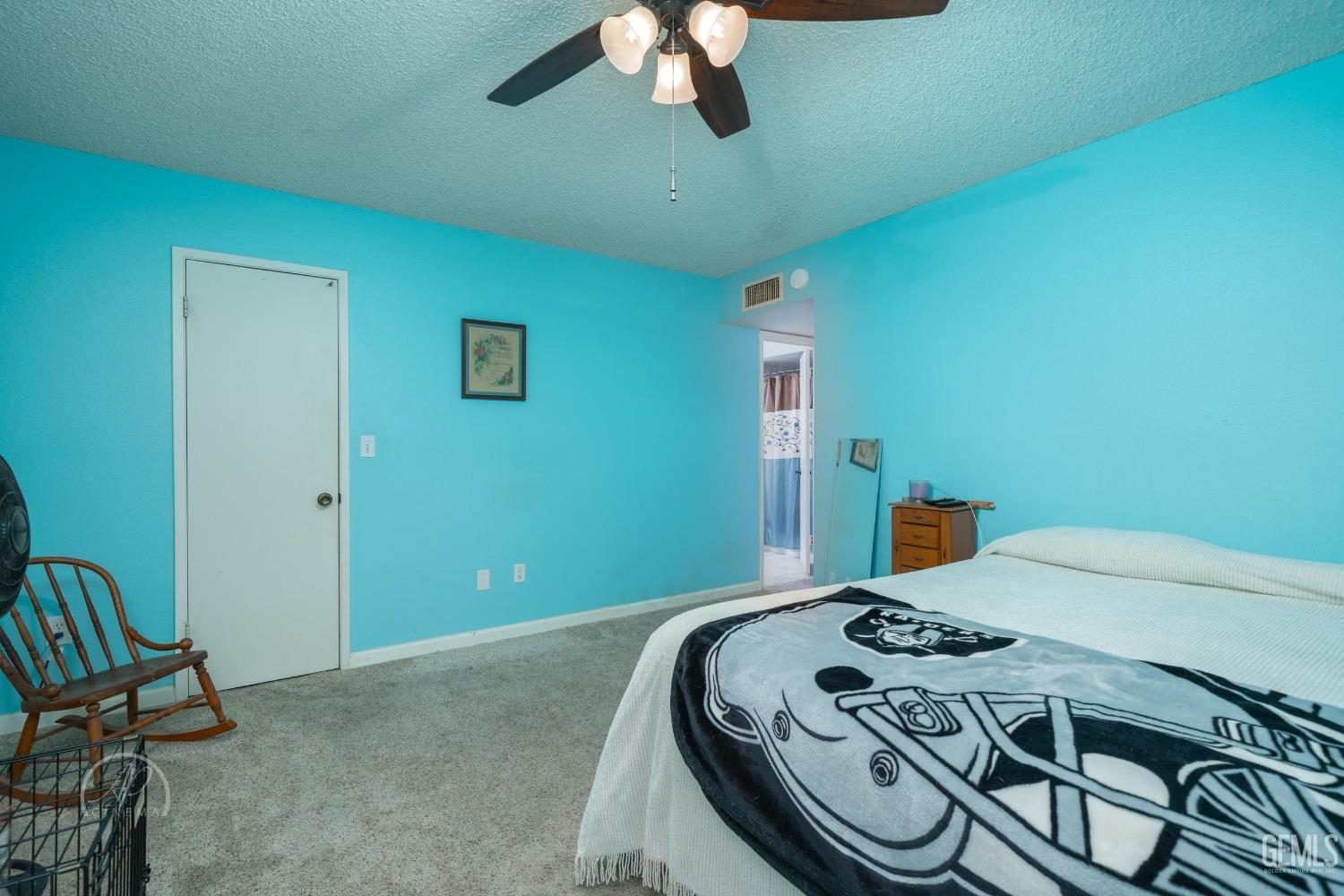 Undisclosed Address Taft, CA 93268 - Photo 18 of 32 a bed sitting in a bedroom next to a window and a chandelier