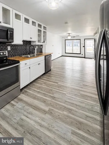 a kitchen with granite countertop a stove a sink and a refrigerator