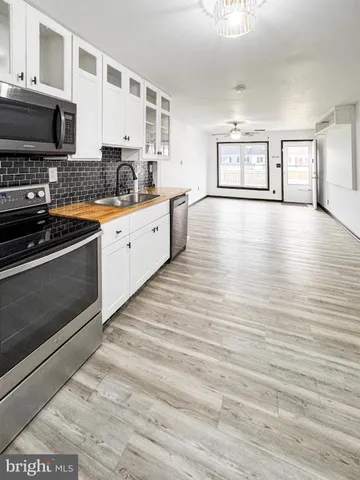 a kitchen with stainless steel appliances kitchen island granite countertop a stove and a sink
