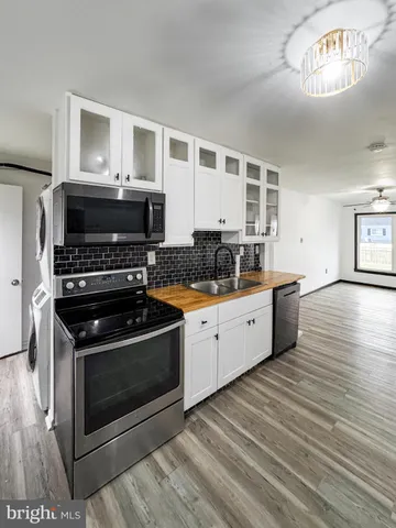a kitchen with stainless steel appliances a stove a sink and a microwave