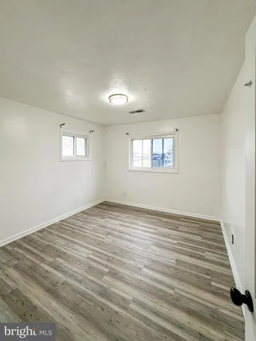 a view of a room with wooden floor and white walls