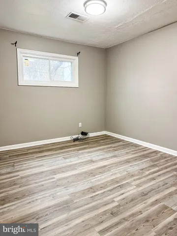 an empty room with wooden floor and closet