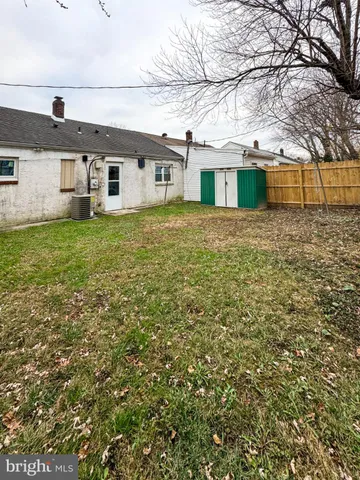 a view of a yard in front of a house with large tree