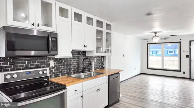 a kitchen with stainless steel appliances a stove and a microwave