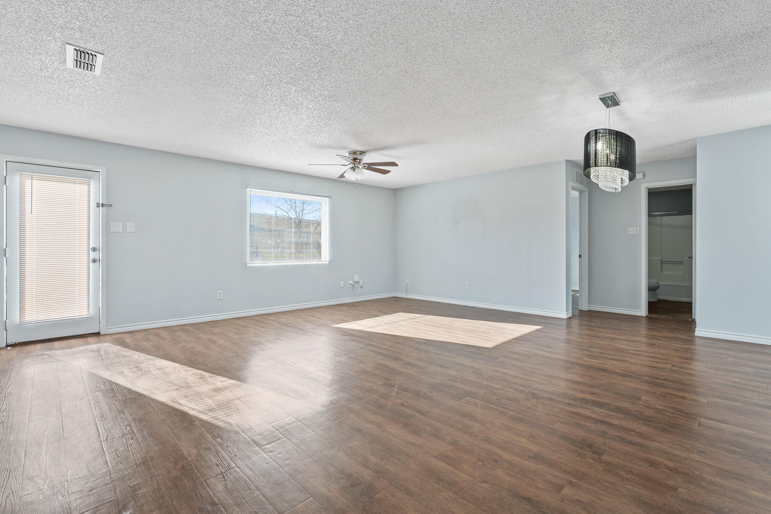 5705 Itasca Street Lubbock, TX 79416 - Photo 2 of 10 an empty room with wooden floor and windows