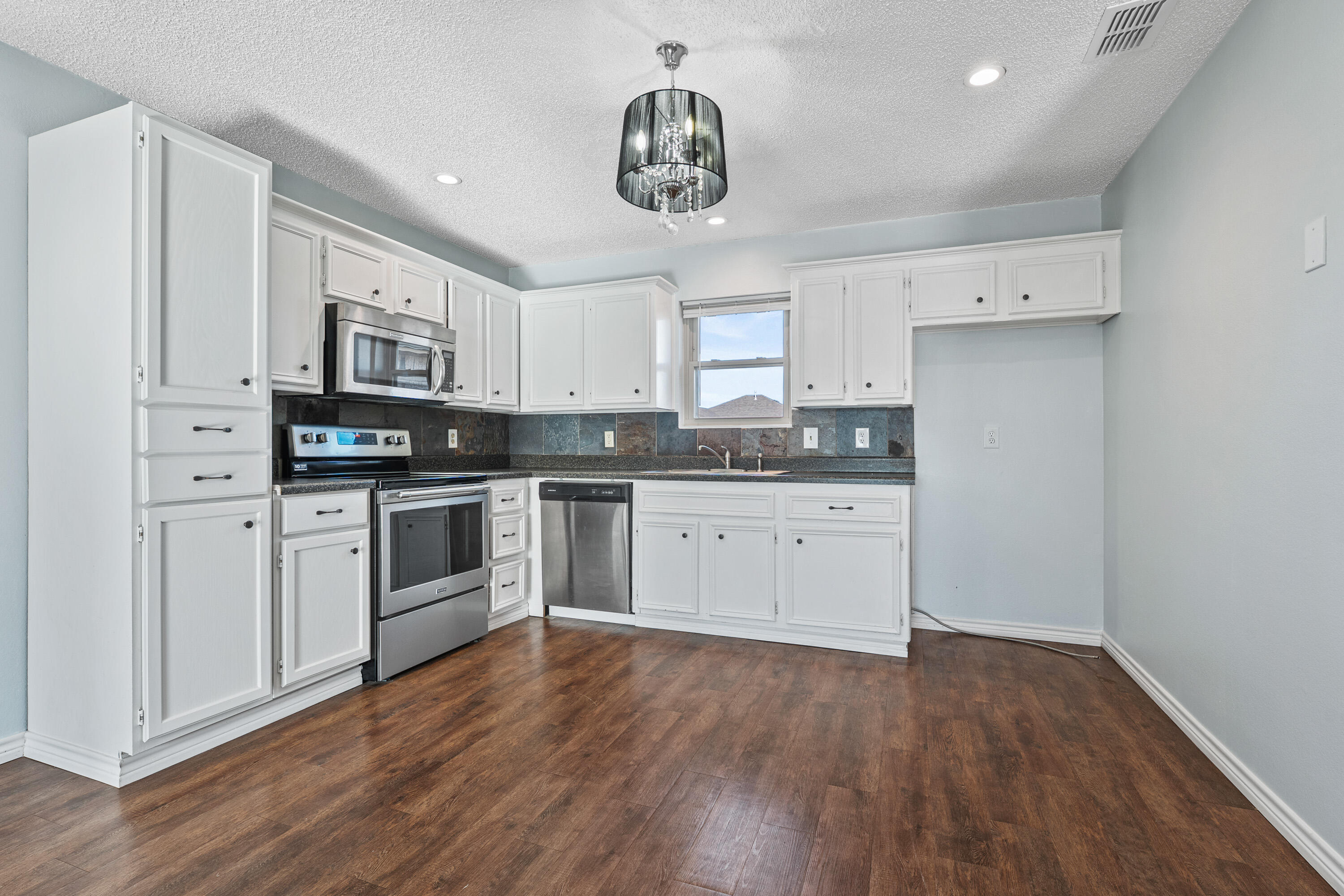 5705 Itasca Street Lubbock, TX 79416 - Photo 4 of 10 a kitchen with granite countertop white cabinets and white appliances