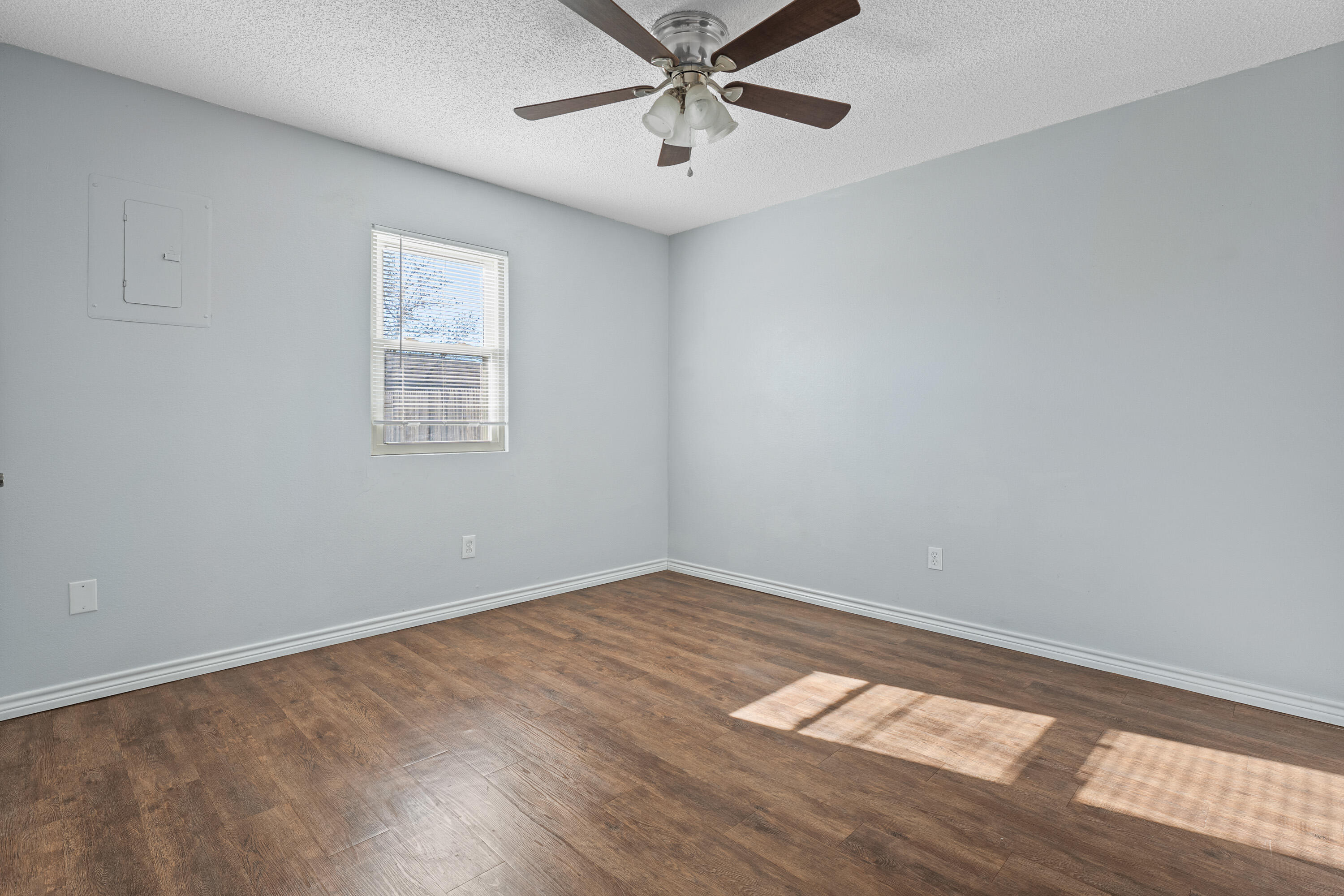 5705 Itasca Street Lubbock, TX 79416 - Photo 5 of 10 wooden floor in an empty room with a window
