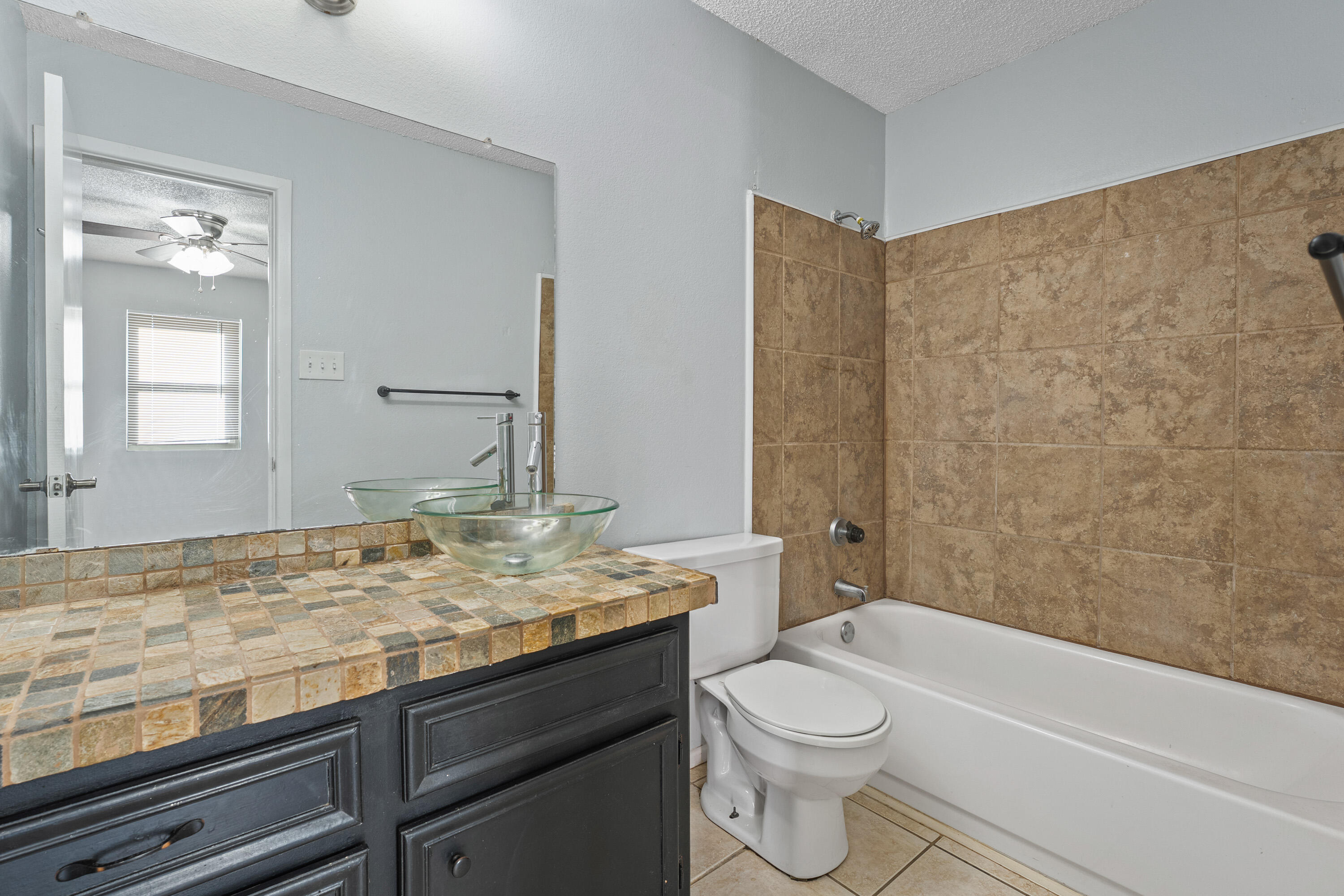 5705 Itasca Street Lubbock, TX 79416 - Photo 9 of 10 a bathroom with a granite countertop sink toilet mirror and bathtub
