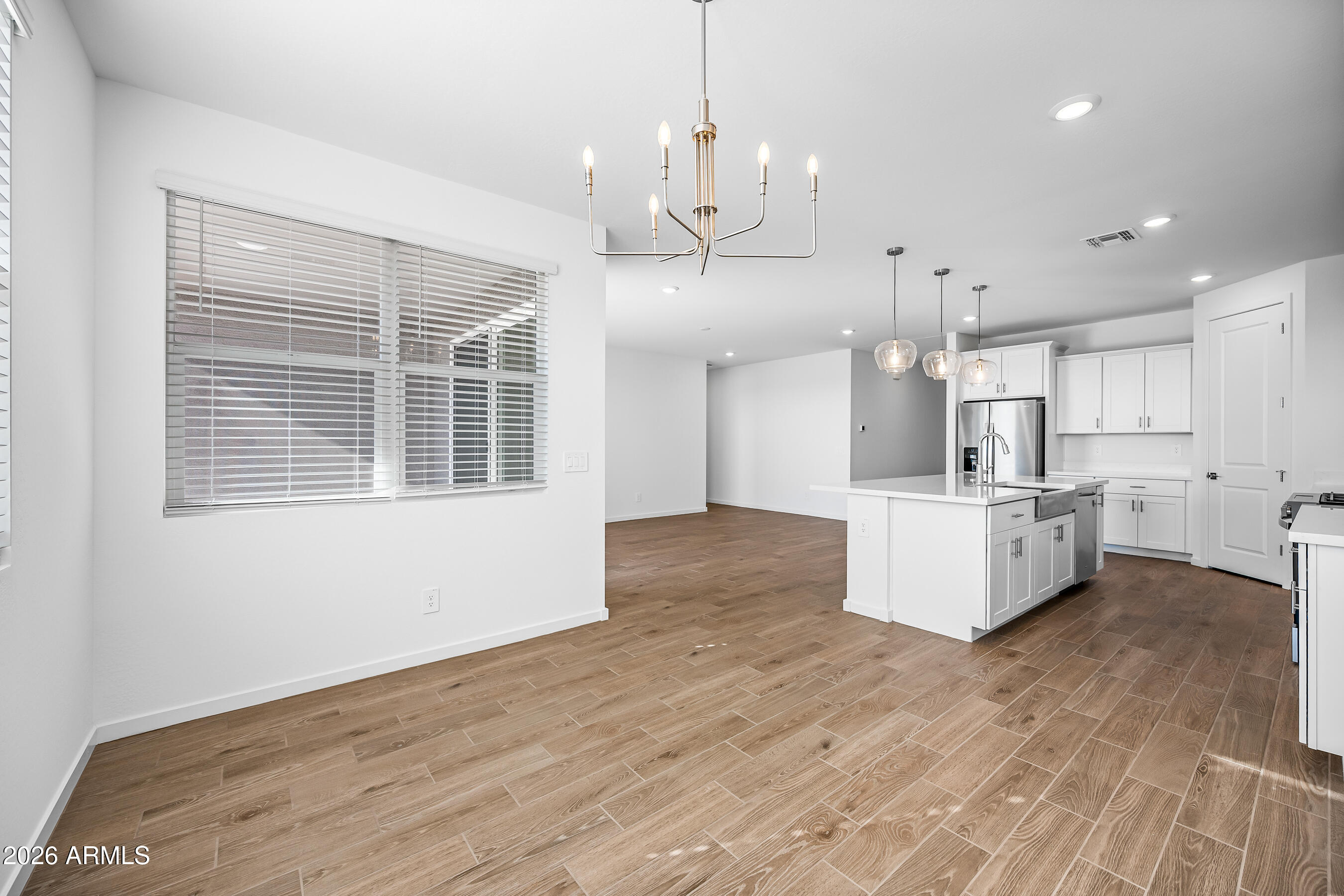 2563 Grenache Road San Tan Valley, AZ 85143 - Photo 11 of 25 a large kitchen with kitchen island a stove a sink a center island and wooden floor