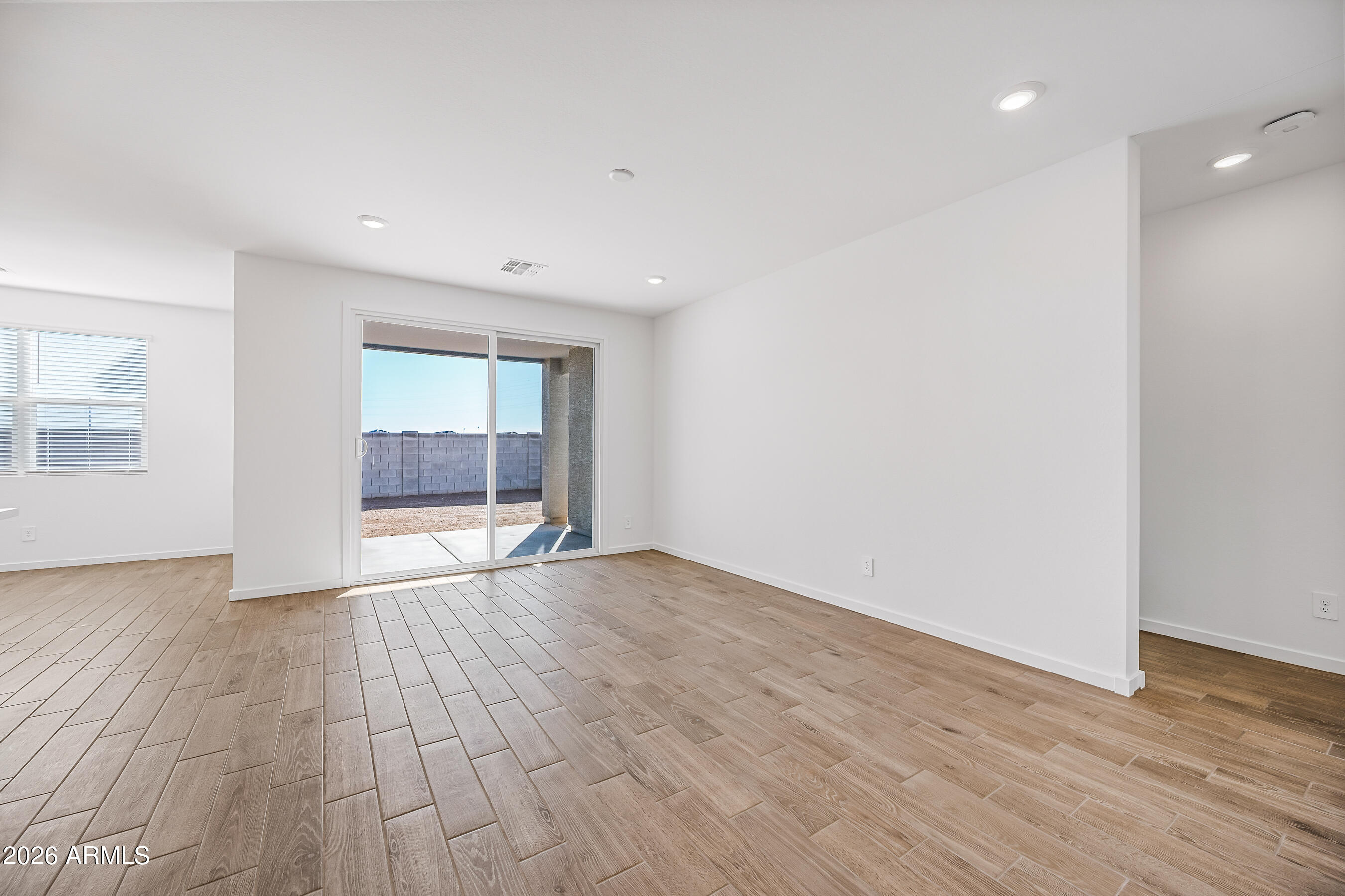 2563 Grenache Road San Tan Valley, AZ 85143 - Photo 3 of 25 a view of an empty room with wooden floor and a window