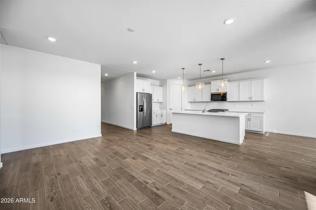 a view of kitchen with granite countertop cabinets and refrigerator