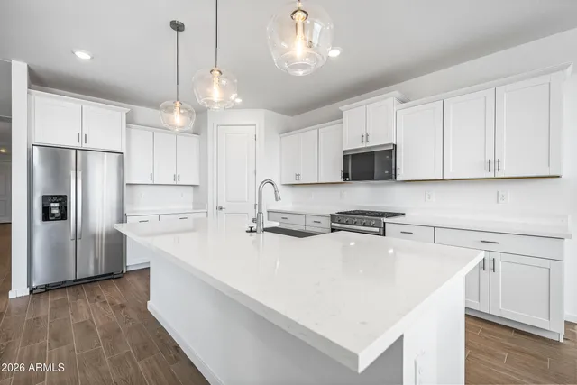 a kitchen with kitchen island a white counter top space cabinets and stainless steel appliances