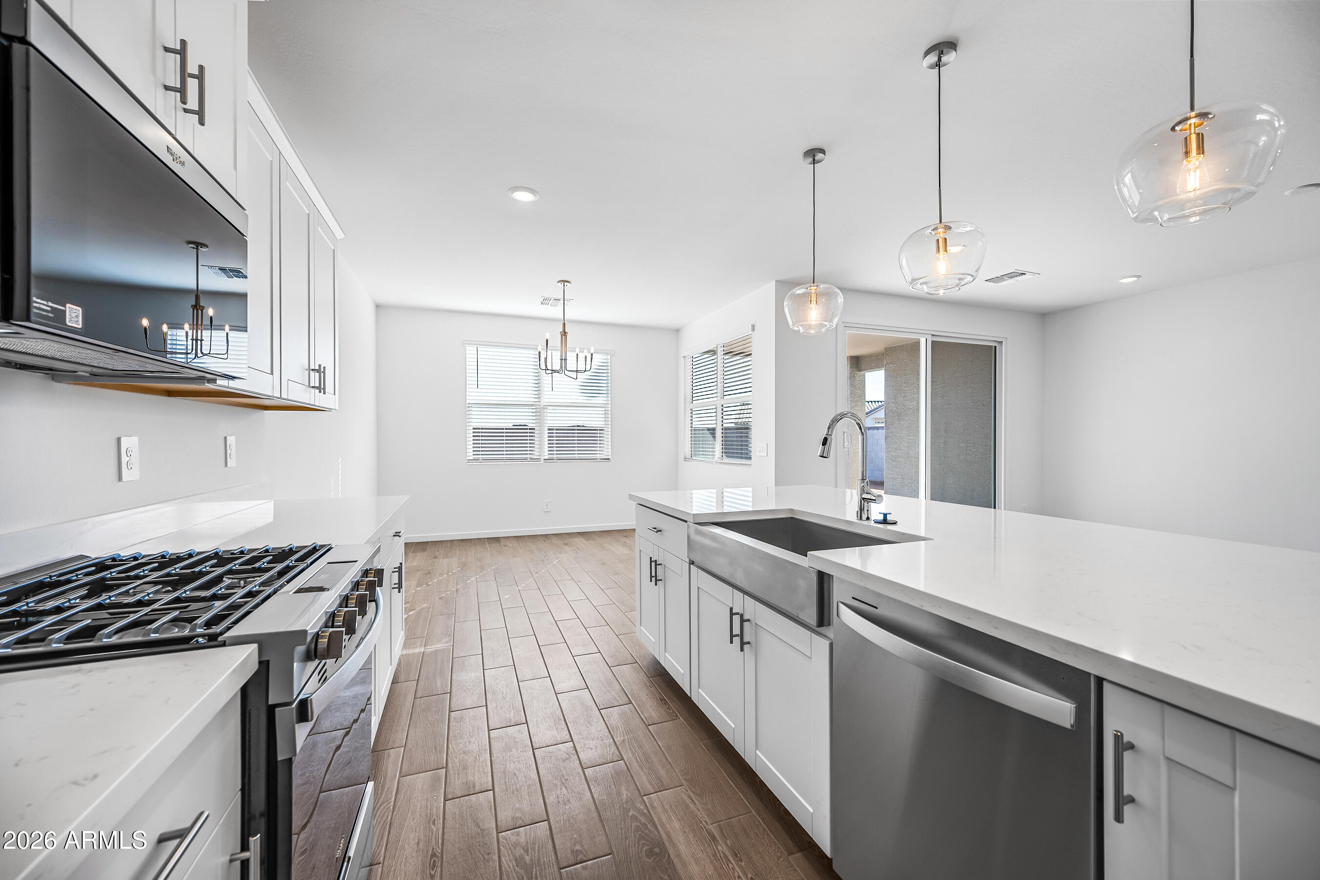 2563 Grenache Road San Tan Valley, AZ 85143 - Photo 9 of 25 a kitchen that has a sink a stove and a wooden floor