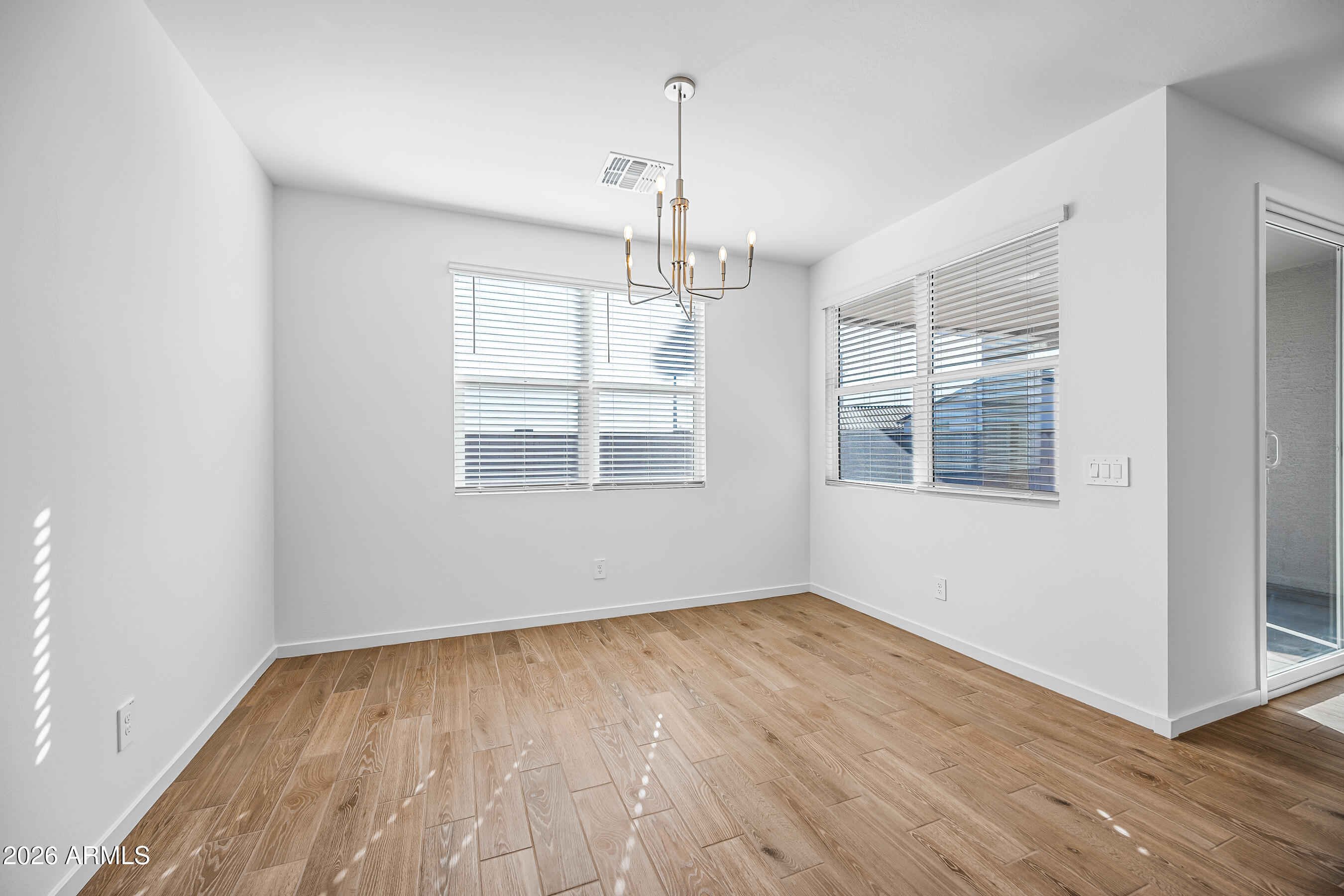 2563 Grenache Road San Tan Valley, AZ 85143 - Photo 10 of 25 a view of an empty room with wooden floor and windows