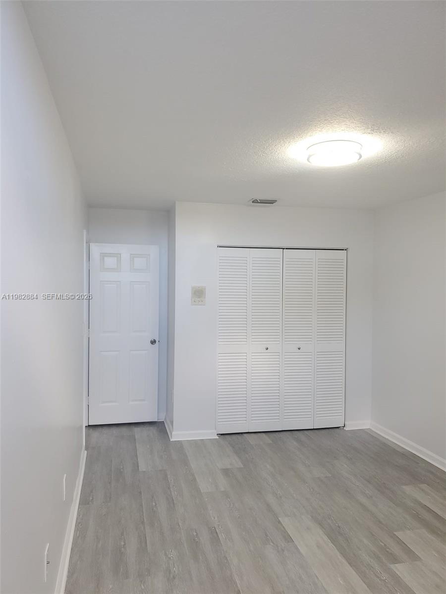 14765 Southwest 132nd Place Miami, FL 33186 - Photo 20 of 52 an empty room with wooden floor and windows in it