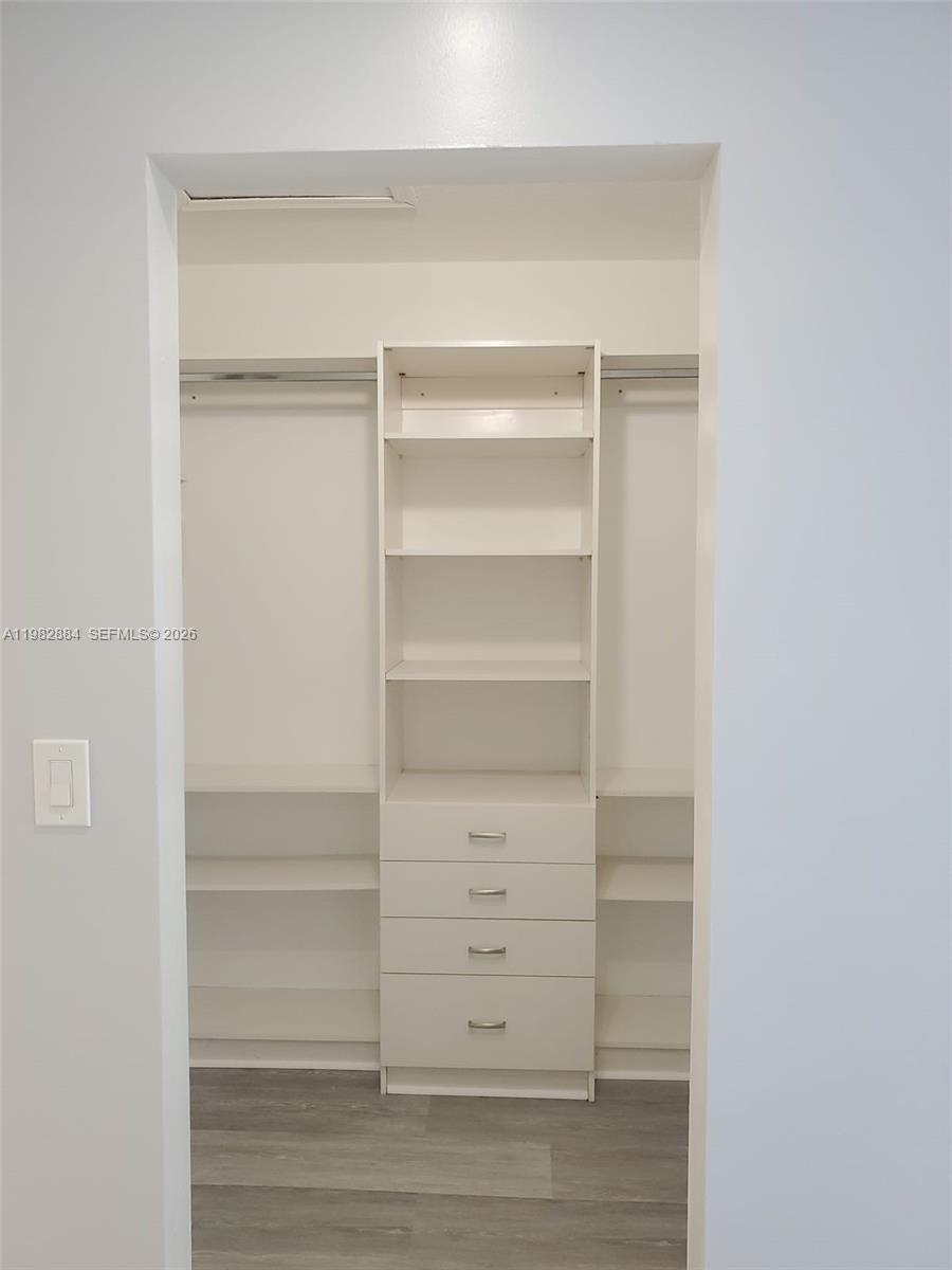 14765 Southwest 132nd Place Miami, FL 33186 - Photo 25 of 52 a view of walk in closet with empty racks