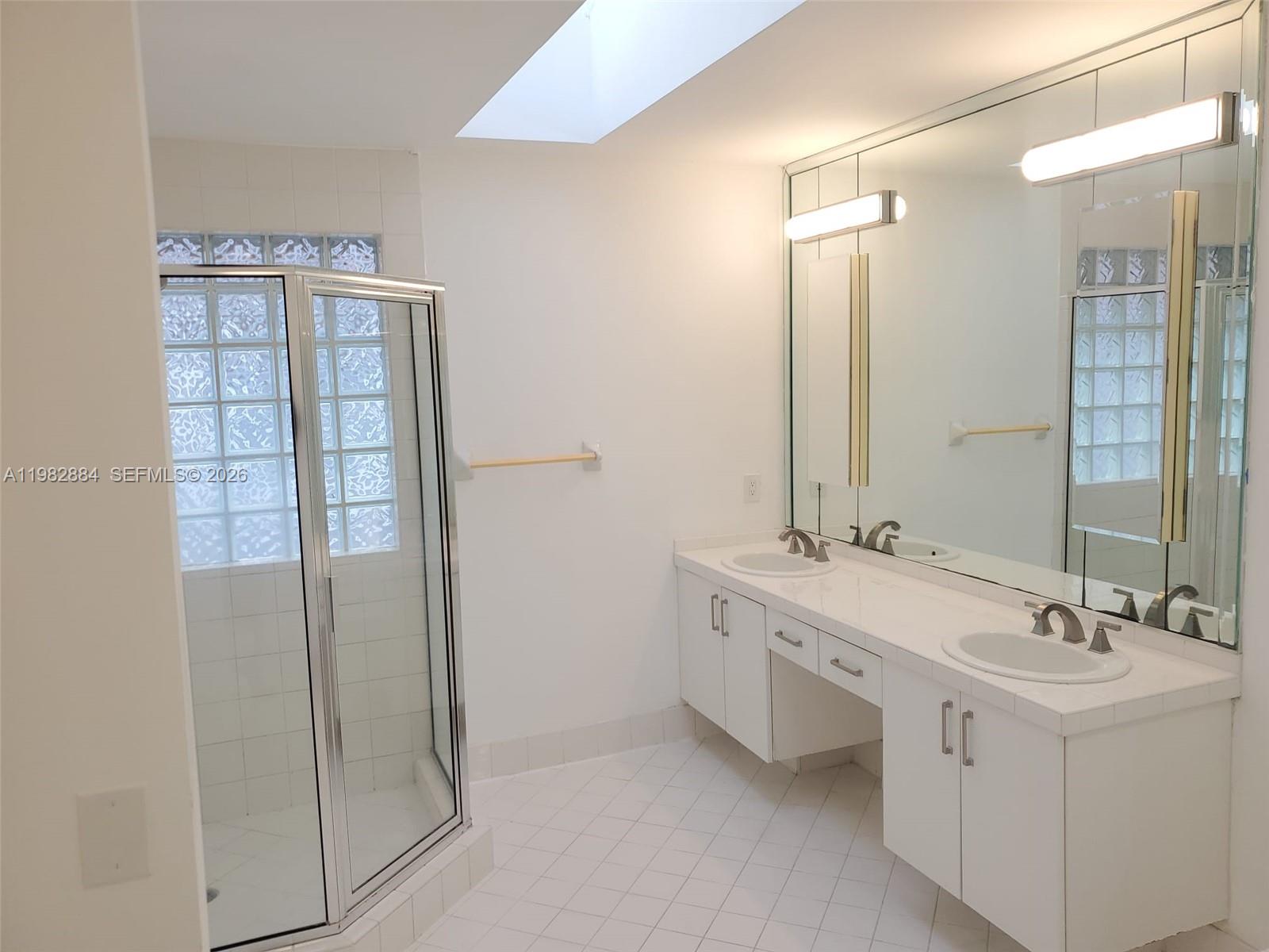 14765 Southwest 132nd Place Miami, FL 33186 - Photo 27 of 52 a bathroom with a double vanity sink a toilet and shower