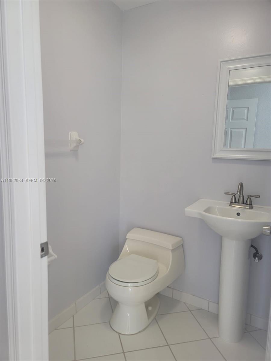 14765 Southwest 132nd Place Miami, FL 33186 - Photo 30 of 52 a bathroom with a toilet a sink and mirror