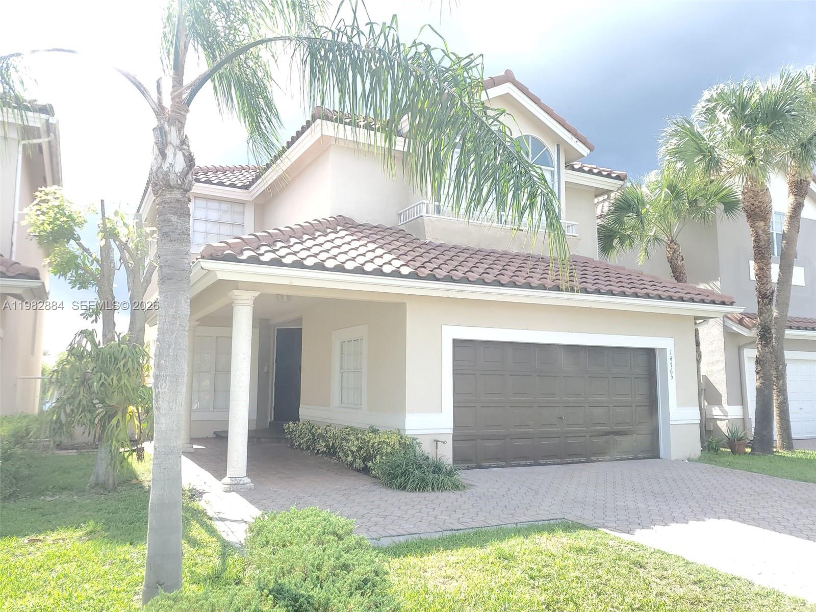 14765 Southwest 132nd Place Miami, FL 33186 - Photo 3 of 52 a front view of a house with a yard and garage