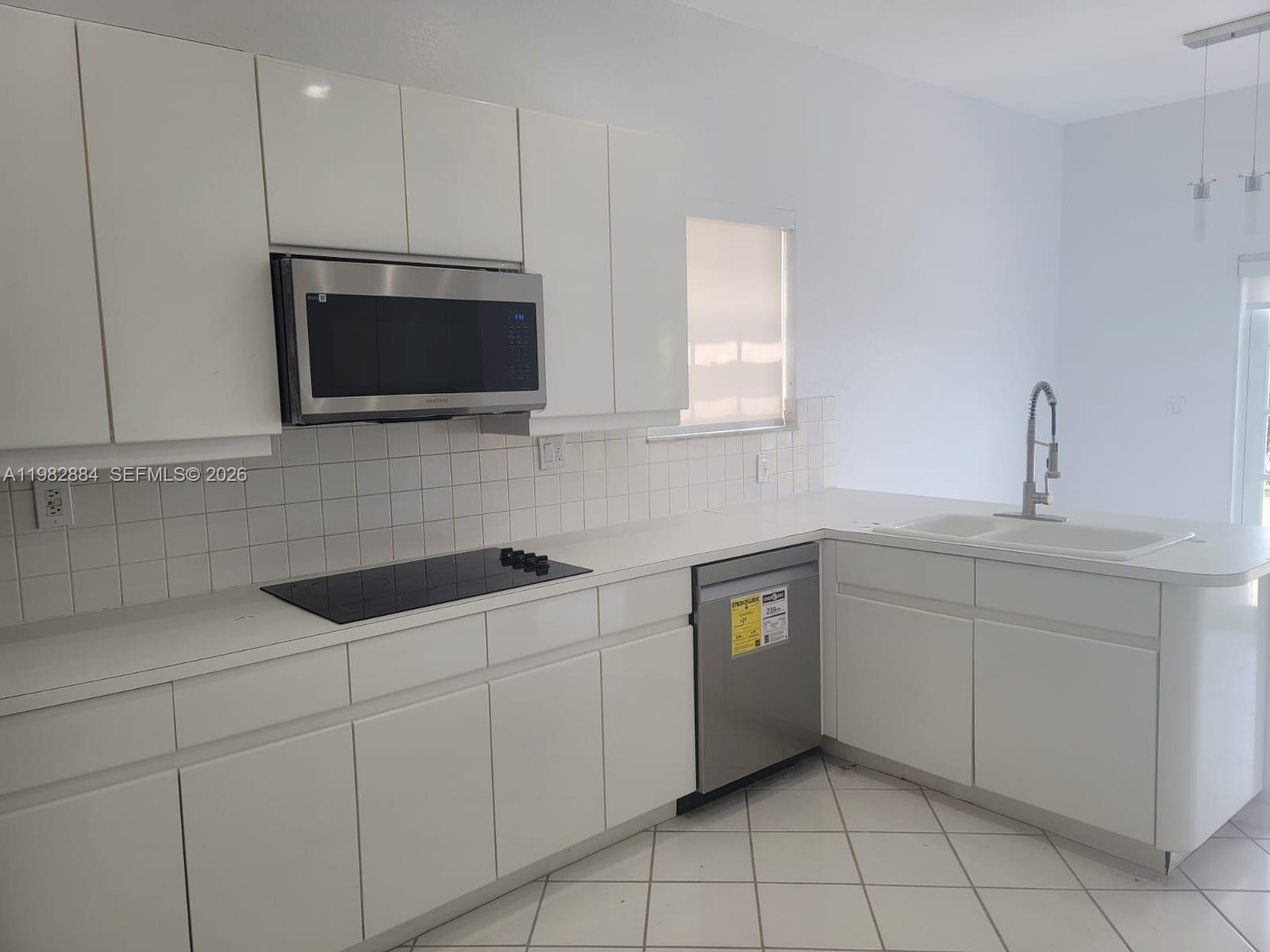 14765 Southwest 132nd Place Miami, FL 33186 - Photo 34 of 52 a kitchen with white cabinets a sink and appliances