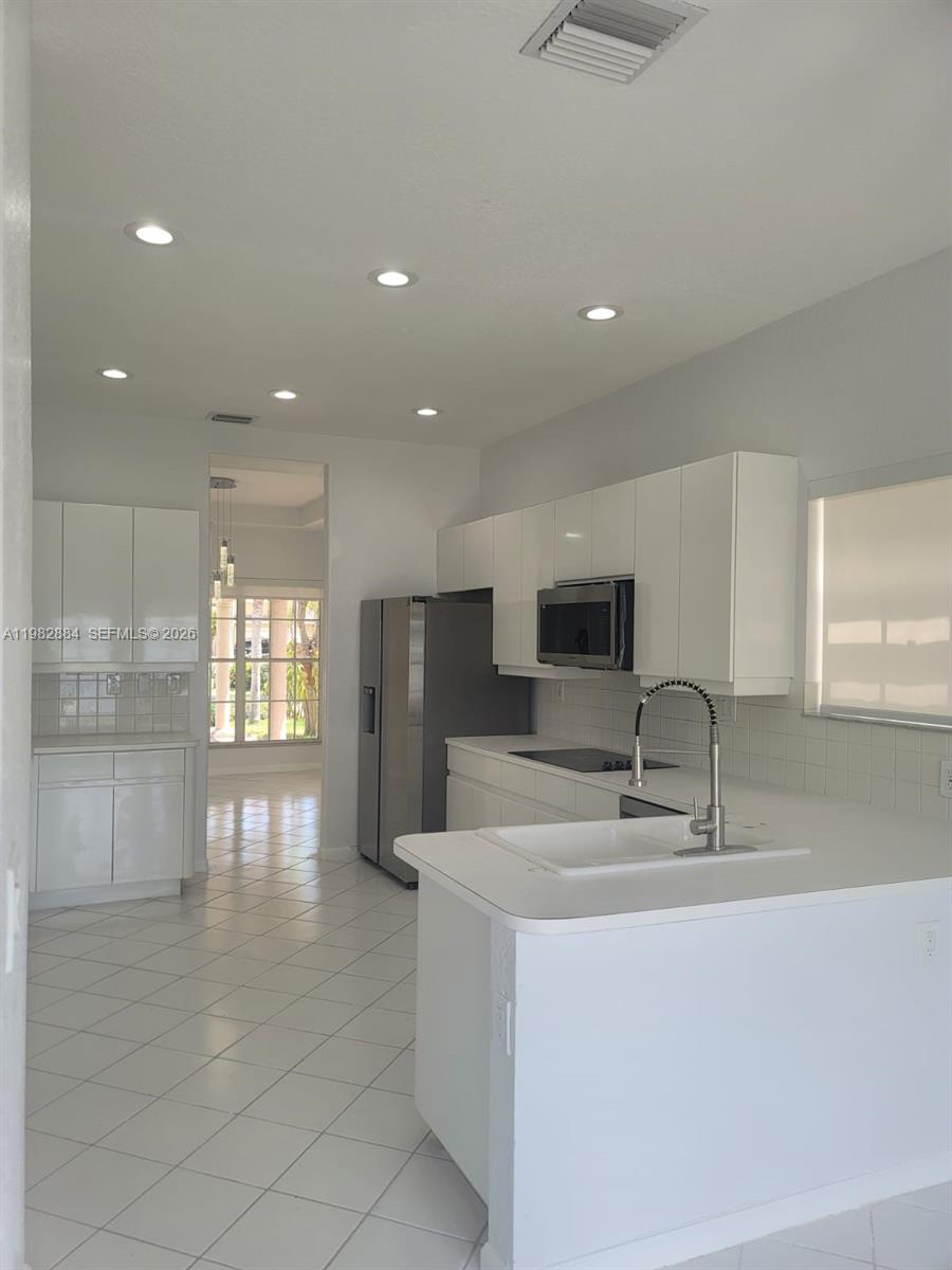 14765 Southwest 132nd Place Miami, FL 33186 - Photo 35 of 52 a kitchen with stainless steel appliances a sink and a refrigerator