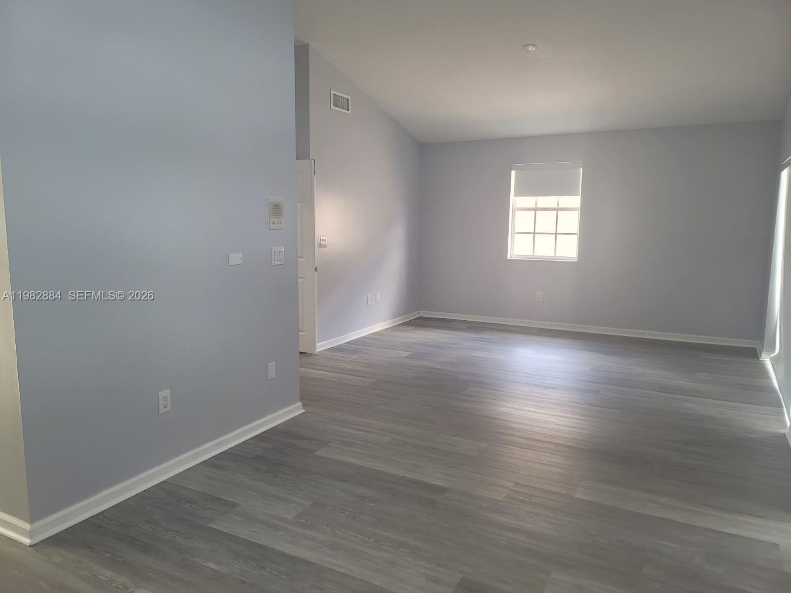 14765 Southwest 132nd Place Miami, FL 33186 - Photo 37 of 52 an empty room with wooden floor and windows