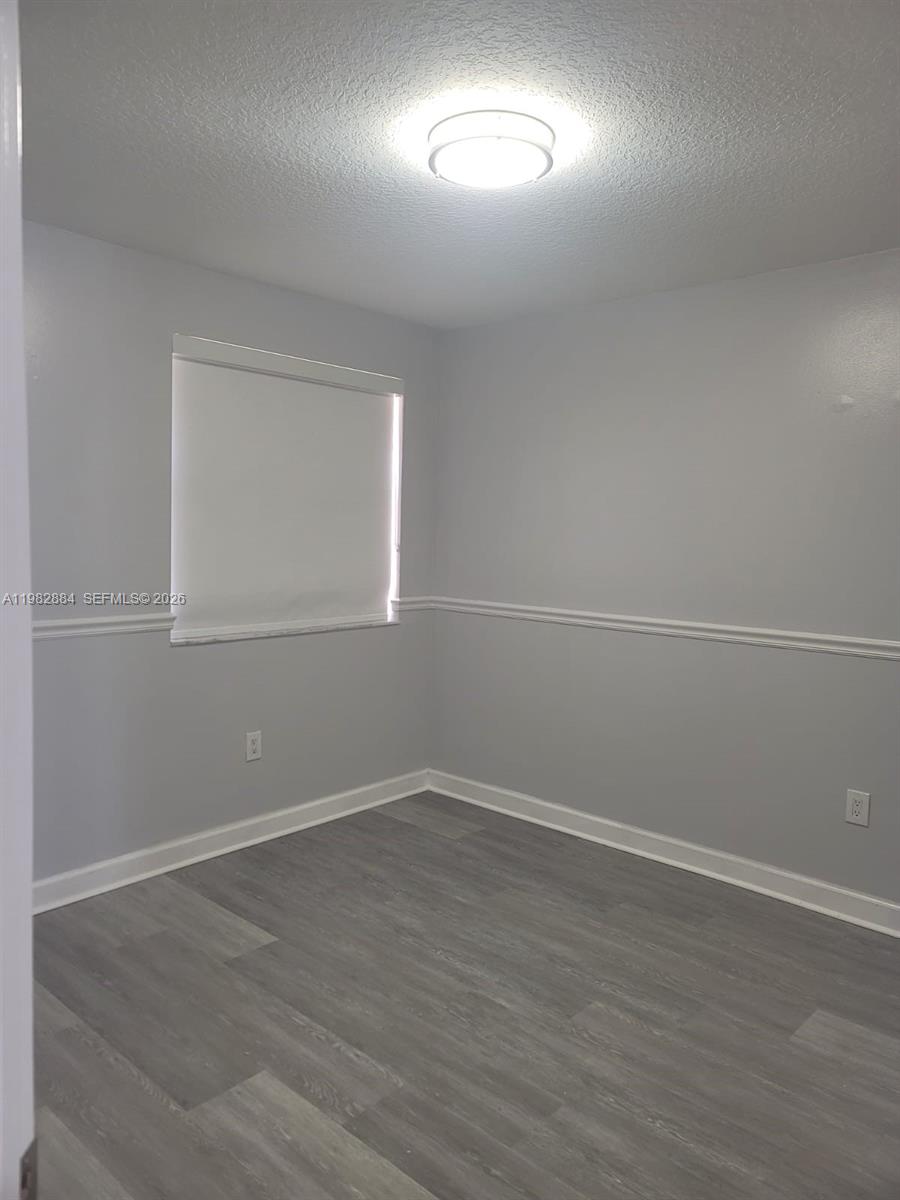 14765 Southwest 132nd Place Miami, FL 33186 - Photo 41 of 52 an empty room with wooden floor and windows