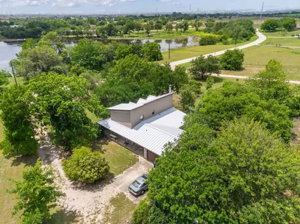 an aerial view of a house with a yard and lake view