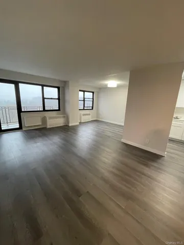 an empty room with wooden floor and window