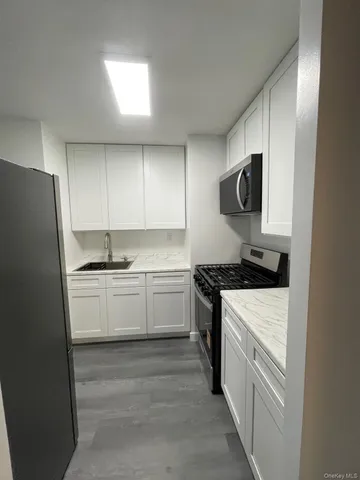 a kitchen with granite countertop white cabinets and white appliances