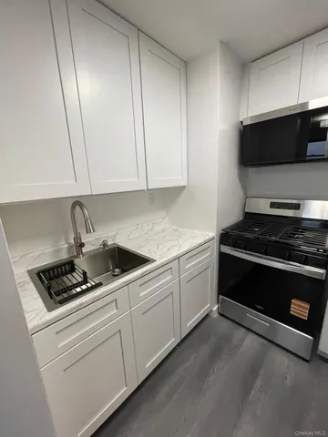 a kitchen with stainless steel appliances white cabinets and a stove top oven